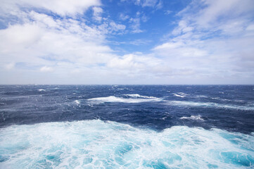 Naklejka na ściany i meble Blue ocean wave on Windy Rough sea day. Cruise ship Vacation. Big surf.