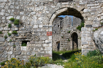 Fototapeta na wymiar Old stone wall with windows and a doorway.