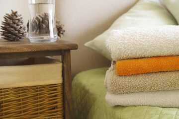 Bedroom interior. Stack of towels on bed. Selective focus.