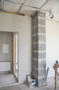 An Inside View On Unfinished House Construction With A Chimney Liner Inserted Into A Soapstone Flue Liner, Ventilation Pipes, Electrical Wiring, And Ceiling Insulation Installed.