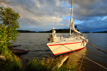 Yacht anchored to the rocky shore. 32 feet swedish built cruising sailboat. Ridön island, lake...