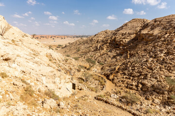 Valley of the Caves in Mleiha Archaeological Centre in Sharjah, footpath leading to neolithic period caves, limestone mountains landscape.