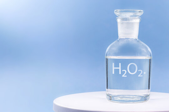 reagent glass, hospital container with antiseptic, written in english the formula h2o2, with copy space