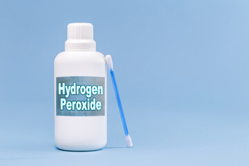 plastic container, medicine bottle, written in english: hydrogen peroxide, isolated blue background, concept of first care