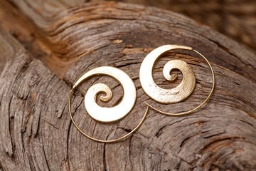 Ornamental brass metal earrings on natural background