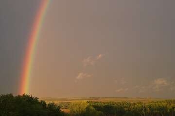 a bright rainbow in a gloomy sky after rain