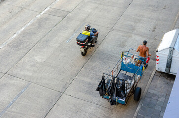 top view of a homeless man pulling a garbage cart on the streets in Brazil