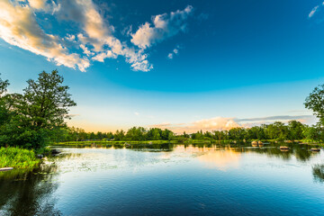 Quiet lake in the forest by the light of the setting sun