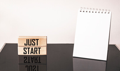 Just start action concept written on wooden blocks and black and white background.