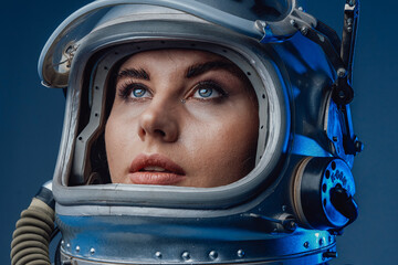 Female modern cosmonaut in spacesuit and helmet - obrazy, fototapety, plakaty