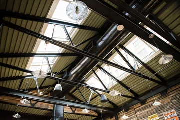 Foto auf Alu-Dibond Interior of industrial roof rafters with dramatic light and shadow © Jessica