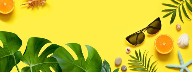 Summer background. Palm leaf, orange, starfish and seashell on yellow background. Travel.