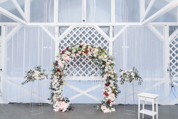 Beautiful modern hexagon wedding arch for unique contemporary wedding ceremony with fresh greenery and lights and candles.