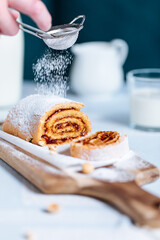 Strudel served on a wooden board and glass of milk
