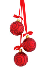 Three glossy red glass glitter Christmas baubles (decoration) hanging on a red satin ribbon with a...