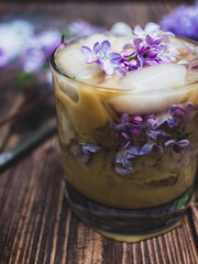 Cold summer coffee drink with lilac flowers 