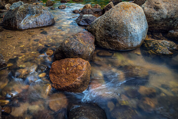 Water flowing through stones and down small rock steps natural scene.