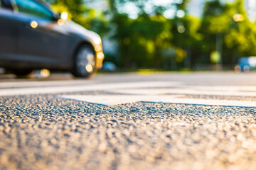 Sunny day in a city, view of the driving car to the road level