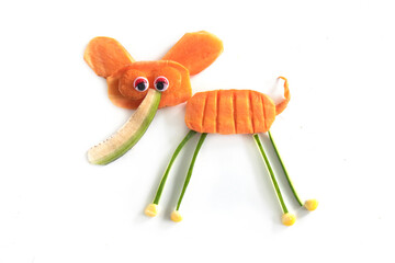 Food art creative concepts. Funny elephant made of fruits and vegetables, such as carrots and cucumber isolated on a white background.