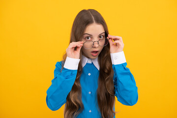 Just curious. Curious girl in eyeglasses. Nerdy-looking kid yellow background. Back to school