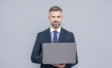 mature manager with grizzled hair in formal suit working on computer online, freelancer