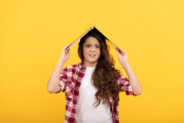 Fototapeta premium Unhappy school girl worry holding laptop computer on head for distance education, telelearning