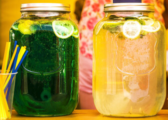 Two banks with cocktails with lemons. The refreshing drinks in the summer. cooling drinks during a summer heat.