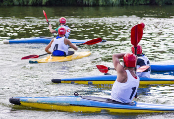 Athletes on a canoe with oars and helmets. Rafting. Active phase of the game canoe polo