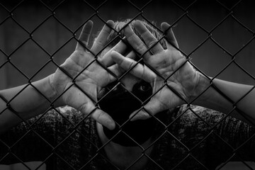Prisoner hands on fence