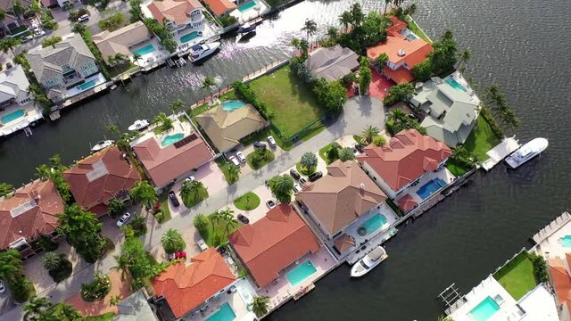 Aerial Top Forward Shot Of Houses Amidst Sea In City, Drone Flying Over Nautical Vessels On Sunny Day - Miami, Florida