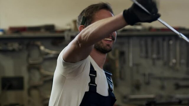 Portrait of the young mechanic with the wrench.