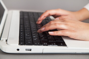 Female hands on a white computer keyboard.