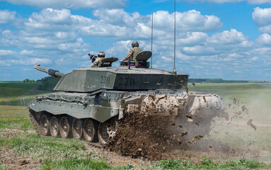close up of a british army Challenger 2 main battle tank in action on a military exercise,  throwing up mud Wiltshire UK