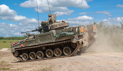 Fototapeta na wymiar british army FV510 Warrior light infantry fighting vehicle tank kicking up dirt in action on a military exercise Wiltshire UK