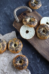 Ruddy bagels with sesame seeds and poppy seeds on a wooden board. Traditional pastries.