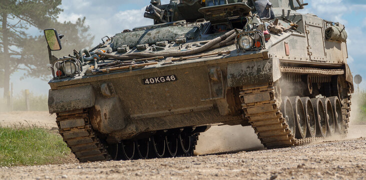 british army FV510 Warrior light infantry fighting vehicle tank kicking up dirt in action on a military exercise Wiltshire UK