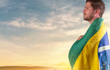 Fotobehang Brazilian man with Brazilian flag looking at the horizon  © Daniel Reche
