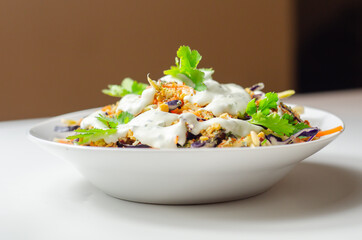 Coleslaw salad with dressing and croutons sprinkle, broccoli, carrot, red cabbage and onion in the white plate