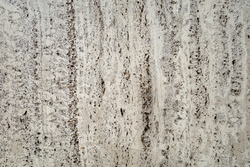 Rough white natural stone travertine with small random cavities. Limestone building material. 