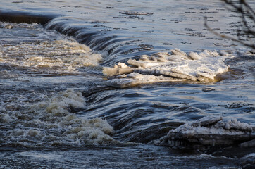 Venta river watarfall in spring day. High water level, so that the waterfall is almost invisible....