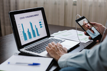 Hispanic man teleworking from home  - Businessman video conferencing while working on laptop in the living room at home