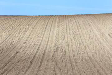 Fototapeta premium Landscape agricultural land in slope recently plowed for the crop