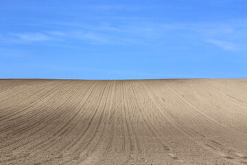 Naklejka premium Landscape agricultural land in slope recently plowed for the crop