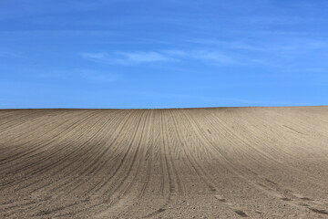 Naklejka premium Plowed cultivated agricultural land field at springtime rural landscape as a background