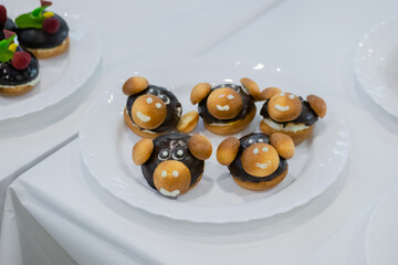 Assortment of delicious fresh shortcrust tart cakes with chocolate and sweet mushrooms on white plate for sale at restaurant, cafe. Dessert, culinary and confectionery concept