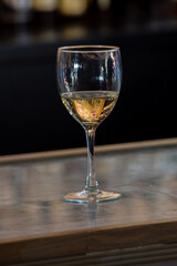 Glass of white wine with graphic art reflections in the liquid. Side view