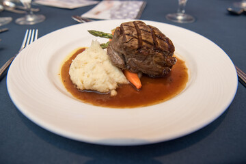 Filet mignon with mashed potatoes and vegetables on a white plate. Overhead view
