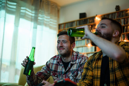 Two Best Friends Playing Video Games While Relaxing At Home On The Couch