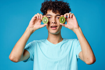 Naklejka premium man with kiwi curly hair near face blue background cropped view