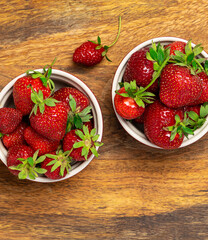Fresh organic strawberries on natural wooden background top view. Healthy natural dessert.